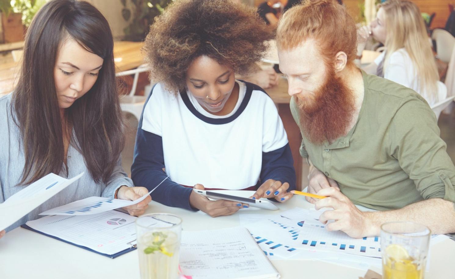 Team collaboration session with financial documents and analysis tools